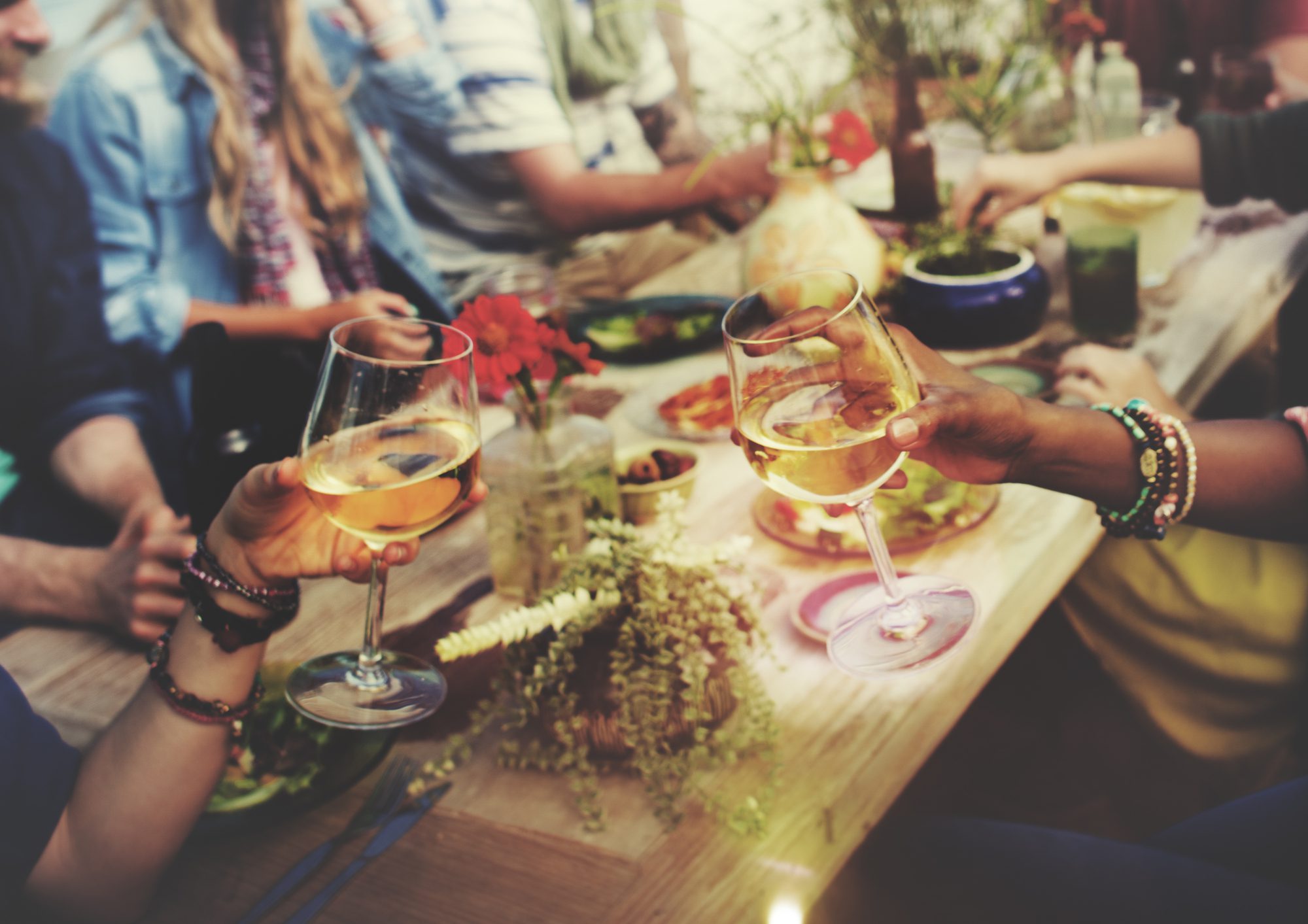 A Group of People Sitting Around a Table Holding Wine Glasses